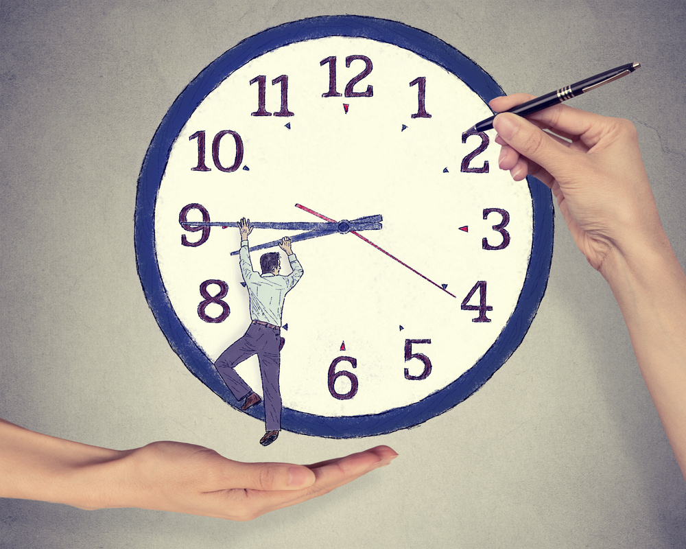 Arbeitnehmer dreht an Uhr während eine Hand mit einem Stift auf Uhr zeigt