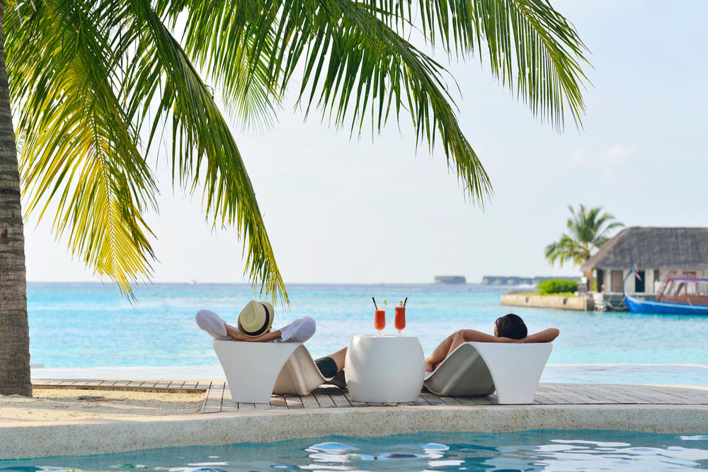 Sommerurlauber am Pool mit Blick aufs Meer